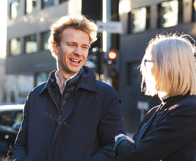 Man laughing looking at a girl in front of a building