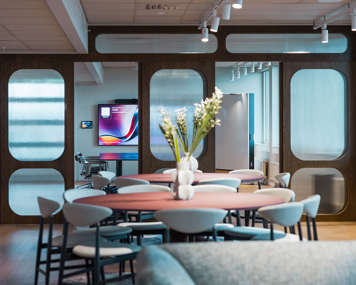 Modern office with seating and a large TV on the back wall.